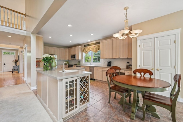 6150 Heritage Lakes Dr, Hilliard, OH 43026 - kitchen with stainless steel appliances, a chandelier, light brown cabinets, light countertops, and a kitchen island with sink