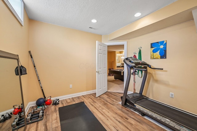 6150 Heritage Lakes Dr, Hilliard, OH 43026 - workout area with light wood-style flooring, a textured ceiling, and recessed lighting