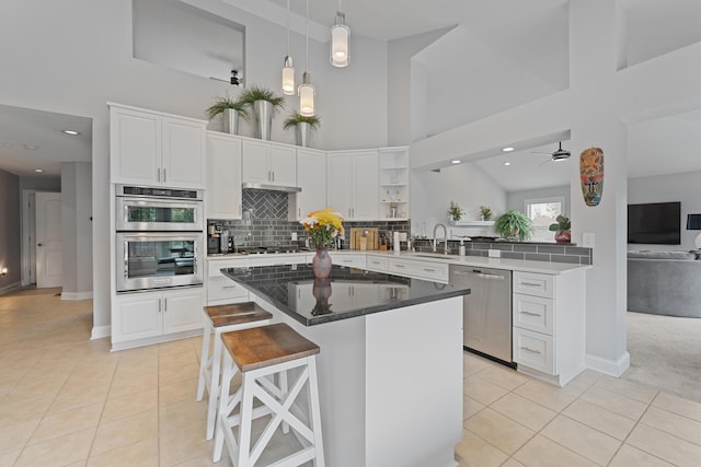 6037 Baronscourt Way, Dublin, OH 43016 - kitchen with stainless steel appliances, a high ceiling, light tile patterned floors, white cabinetry, and tasteful backsplash