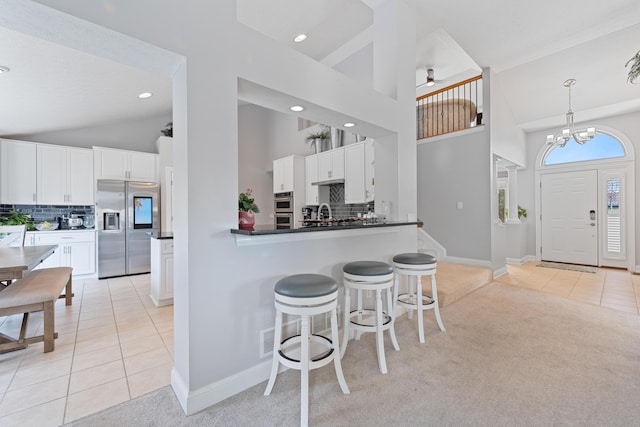 6037 Baronscourt Way, Dublin, OH 43016 - kitchen with appliances with stainless steel finishes, light tile patterned flooring, decorative backsplash, high vaulted ceiling, and white cabinets