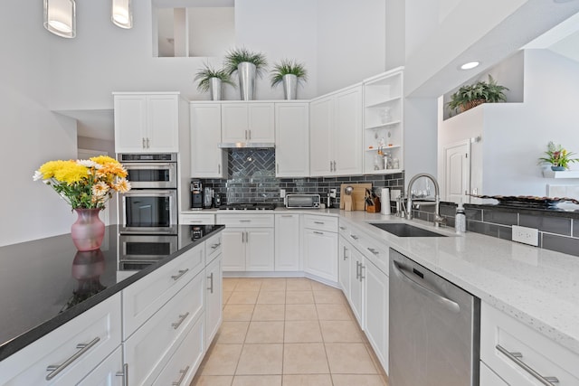 6037 Baronscourt Way, Dublin, OH 43016 - kitchen featuring stainless steel appliances, open shelves, a towering ceiling, backsplash, and light tile patterned floors