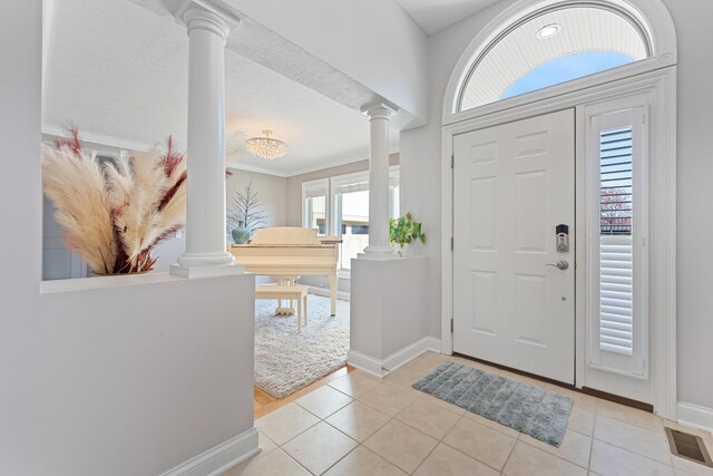 6037 Baronscourt Way, Dublin, OH 43016 - foyer with decorative columns, light tile patterned flooring, and crown molding