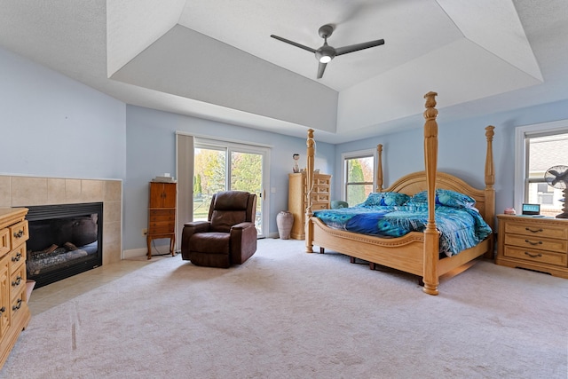 6037 Baronscourt Way, Dublin, OH 43016 - bedroom featuring a tray ceiling, access to exterior, light colored carpet, a tile fireplace, and ceiling fan