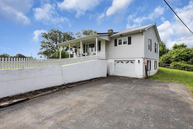 17519 Thompson Ridge Rd, Laurelville, OH 43135 - view of front facade with a porch, a chimney, a garage, a metal roof, and asphalt driveway