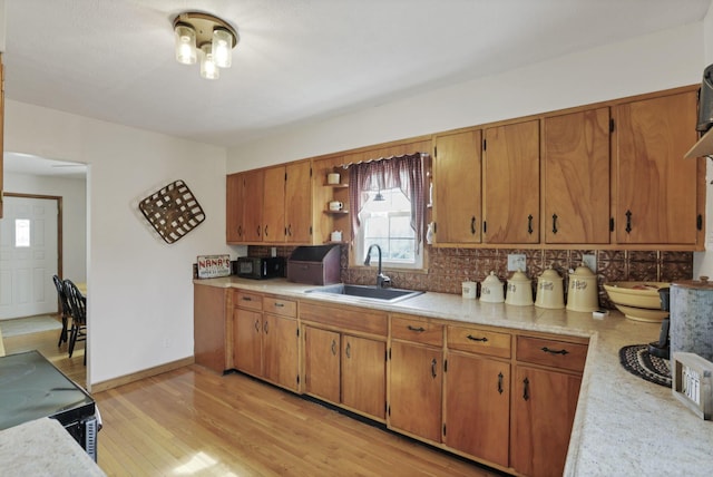 17519 Thompson Ridge Rd, Laurelville, OH 43135 - kitchen featuring light countertops, open shelves, light wood-style floors, brown cabinets, and backsplash