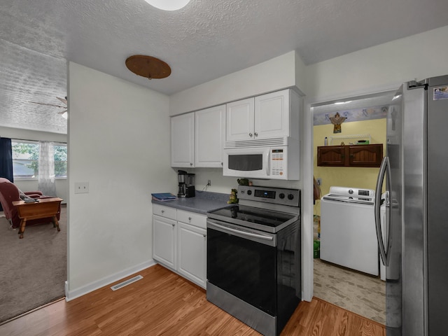 566 Deanna Stroll Rd, Heath, OH 43056 - kitchen featuring appliances with stainless steel finishes, washer / clothes dryer, light wood-style floors, white cabinetry, and a textured ceiling