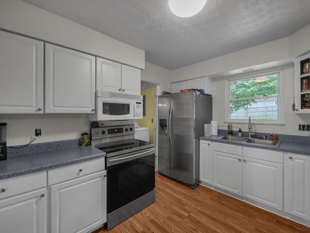 566 Deanna Stroll Rd, Heath, OH 43056 - kitchen featuring stainless steel appliances, white cabinets, a textured ceiling, light wood-type flooring, and dark countertops