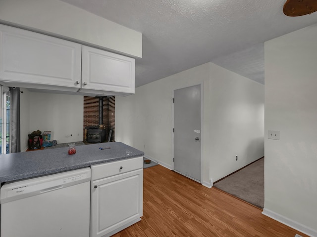 566 Deanna Stroll Rd, Heath, OH 43056 - kitchen featuring white dishwasher, a wood stove, light wood-style flooring, white cabinets, and a textured ceiling