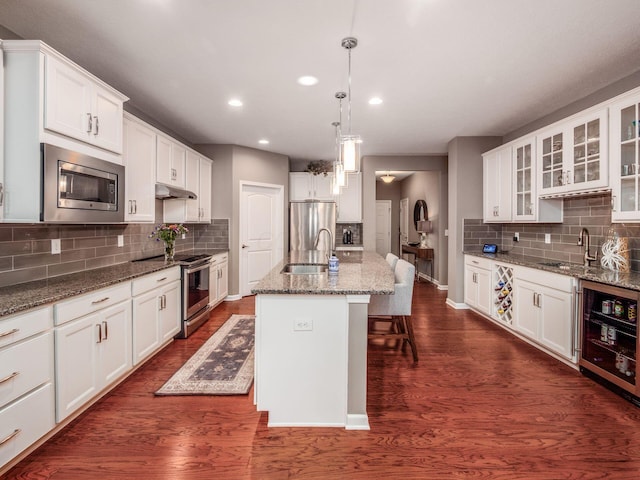 8105 Jitterbug Ln, Pickerington, OH 43147 - kitchen featuring appliances with stainless steel finishes, tasteful backsplash, glass insert cabinets, white cabinets, and beverage cooler