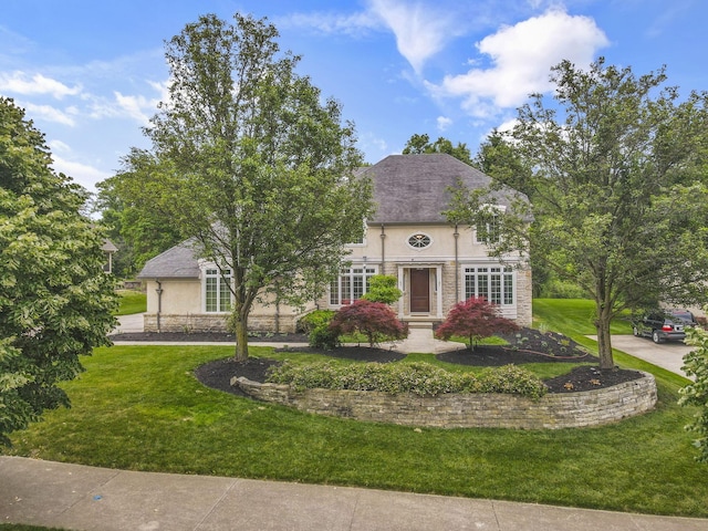 4329 Wyandotte Woods Blvd, Dublin, OH 43016 - view of front facade featuring stucco siding, a front yard, and stone siding