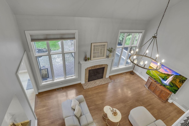 4329 Wyandotte Woods Blvd, Dublin, OH 43016 - living area featuring wood finished floors, healthy amount of natural light, a fireplace, and a chandelier