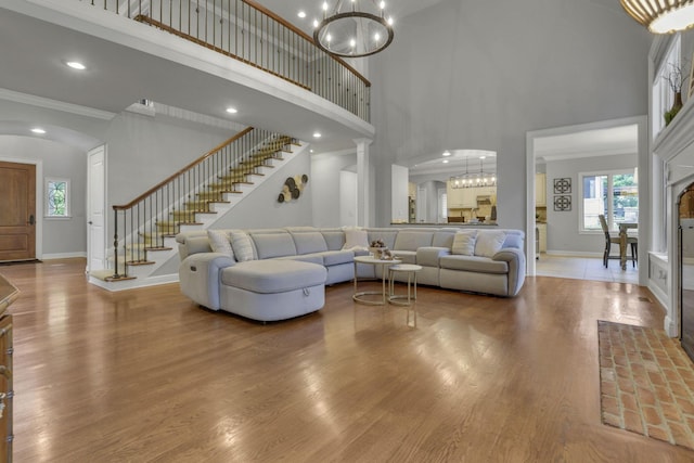4329 Wyandotte Woods Blvd, Dublin, OH 43016 - living area with a towering ceiling, plenty of natural light, a chandelier, wood finished floors, and crown molding