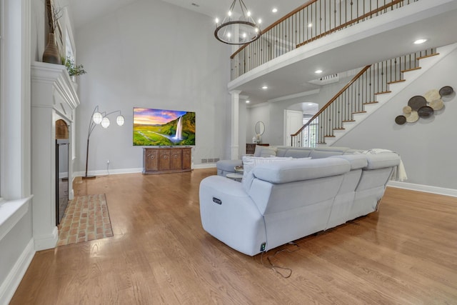 4329 Wyandotte Woods Blvd, Dublin, OH 43016 - living room with a towering ceiling, wood finished floors, stairs, ornate columns, and a chandelier