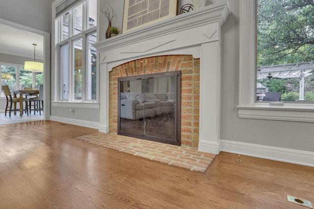 4329 Wyandotte Woods Blvd, Dublin, OH 43016 - detailed view of wood finished floors, a brick fireplace, and ornamental molding