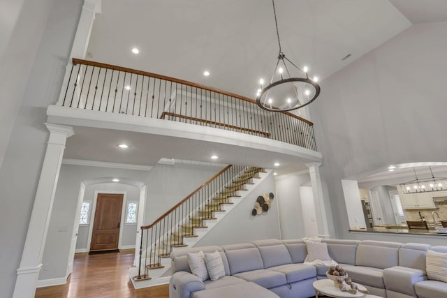 4329 Wyandotte Woods Blvd, Dublin, OH 43016 - living area with a high ceiling, a chandelier, wood finished floors, arched walkways, and stairway
