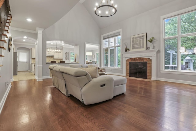 4329 Wyandotte Woods Blvd, Dublin, OH 43016 - living area featuring a chandelier, arched walkways, a brick fireplace, wood finished floors, and high vaulted ceiling