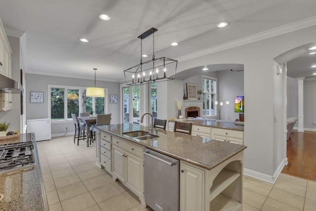 4329 Wyandotte Woods Blvd, Dublin, OH 43016 - kitchen with appliances with stainless steel finishes, arched walkways, stone counters, a fireplace, and light tile patterned floors