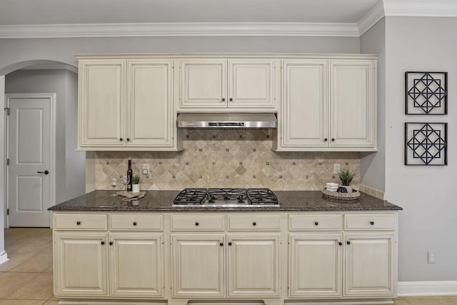 4329 Wyandotte Woods Blvd, Dublin, OH 43016 - kitchen with stainless steel gas stovetop, under cabinet range hood, arched walkways, decorative backsplash, and dark stone countertops