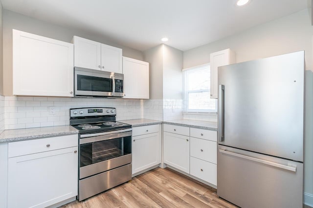 1096 E 22nd Ave Unit 1098, Columbus, OH 43211 - kitchen featuring stainless steel appliances, white cabinets, light wood-type flooring, backsplash, and recessed lighting