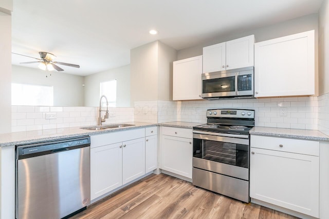 1096 E 22nd Ave Unit 1098, Columbus, OH 43211 - kitchen featuring appliances with stainless steel finishes, ceiling fan, white cabinetry, tasteful backsplash, and recessed lighting