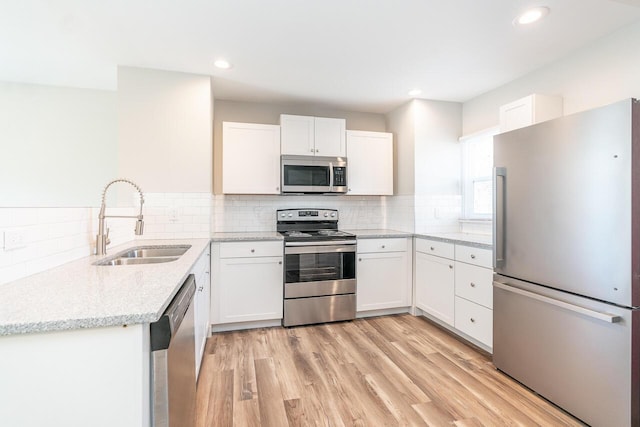 1096 E 22nd Ave Unit 1098, Columbus, OH 43211 - kitchen featuring stainless steel appliances, light stone counters, white cabinetry, tasteful backsplash, and recessed lighting