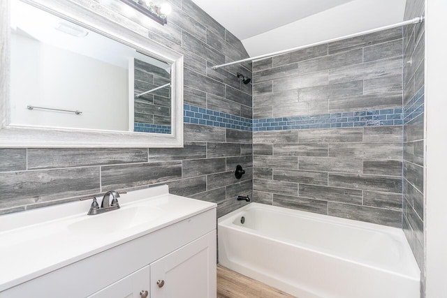 1096 E 22nd Ave Unit 1098, Columbus, OH 43211 - bathroom featuring washtub / shower combination, vanity, tile walls, wood finished floors, and backsplash