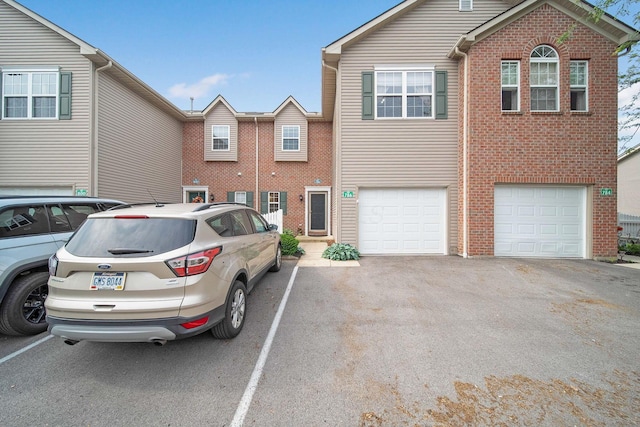 786 Spring Valley Dr, Lewis Center, OH 43035 - townhome / multi-family property with a garage, brick siding, and uncovered parking