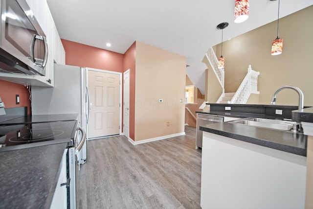 786 Spring Valley Dr, Lewis Center, OH 43035 - kitchen featuring stainless steel appliances, dark countertops, light wood-style flooring, white cabinets, and hanging light fixtures