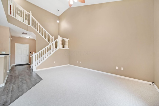 786 Spring Valley Dr, Lewis Center, OH 43035 - unfurnished living room with stairs, carpet flooring, a ceiling fan, and high vaulted ceiling