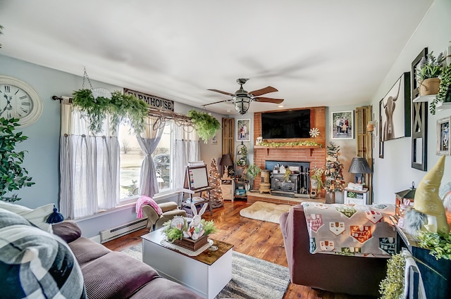 1849 Old Springfield Rd, New Holland, OH 43145 - living room featuring baseboard heating, a ceiling fan, a brick fireplace, and wood finished floors