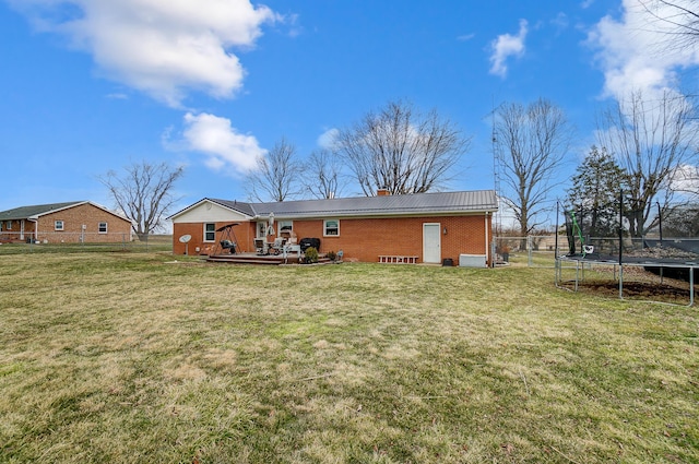 1849 Old Springfield Rd, New Holland, OH 43145 - rear view of house with a trampoline, brick siding, a chimney, and a deck