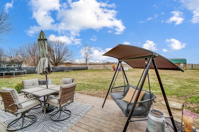 1849 Old Springfield Rd, New Holland, OH 43145 - wooden terrace featuring a trampoline, a playground, outdoor dining space, and a fenced backyard