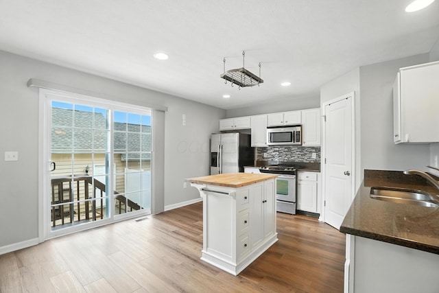 5632 Middle Falls St, Dublin, OH 43016 - kitchen featuring appliances with stainless steel finishes, butcher block counters, white cabinetry, tasteful backsplash, and dark wood-style flooring