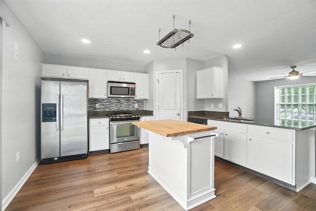 5632 Middle Falls St, Dublin, OH 43016 - kitchen featuring stainless steel appliances, wood counters, a peninsula, white cabinets, and ceiling fan