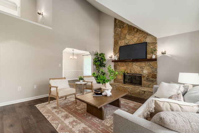 4909 Bixby Rd, Groveport, OH 43125 - living area featuring wood finished floors, a stone fireplace, high vaulted ceiling, a chandelier, and arched walkways