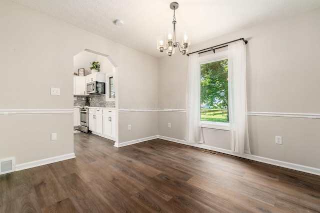 4909 Bixby Rd, Groveport, OH 43125 - empty room featuring a chandelier, arched walkways, and dark wood-type flooring