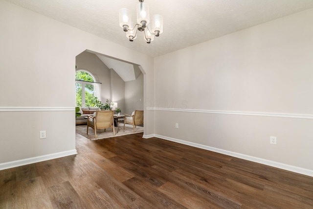 4909 Bixby Rd, Groveport, OH 43125 - spare room with a chandelier, arched walkways, wood finished floors, vaulted ceiling, and a textured ceiling