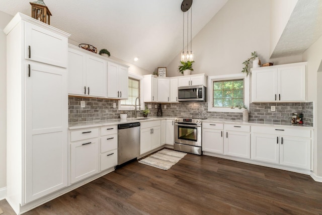 4909 Bixby Rd, Groveport, OH 43125 - kitchen with appliances with stainless steel finishes, dark wood finished floors, light countertops, white cabinetry, and backsplash