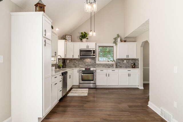 4909 Bixby Rd, Groveport, OH 43125 - kitchen with stainless steel appliances, backsplash, arched walkways, a chandelier, and white cabinets