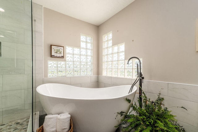 4909 Bixby Rd, Groveport, OH 43125 - full bathroom with tile walls, a soaking tub, and a shower stall