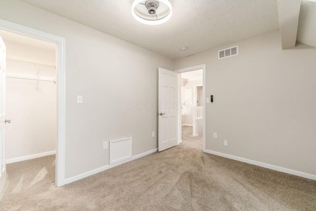 4909 Bixby Rd, Groveport, OH 43125 - unfurnished bedroom featuring a spacious closet, light colored carpet, a textured ceiling, and a closet
