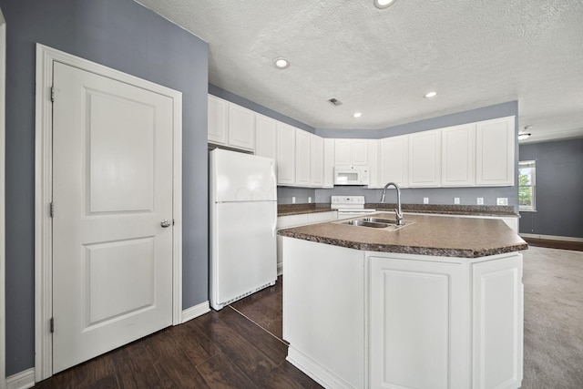 6067 Hayden Farms Rd, Dublin, OH 43016 - kitchen featuring white appliances, dark countertops, white cabinets, an island with sink, and dark wood-style flooring