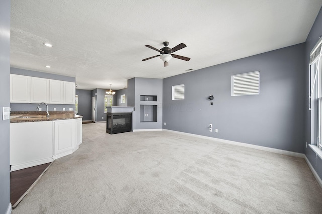 6067 Hayden Farms Rd, Dublin, OH 43016 - unfurnished living room featuring ceiling fan, light carpet, a chandelier, recessed lighting, and a multi sided fireplace