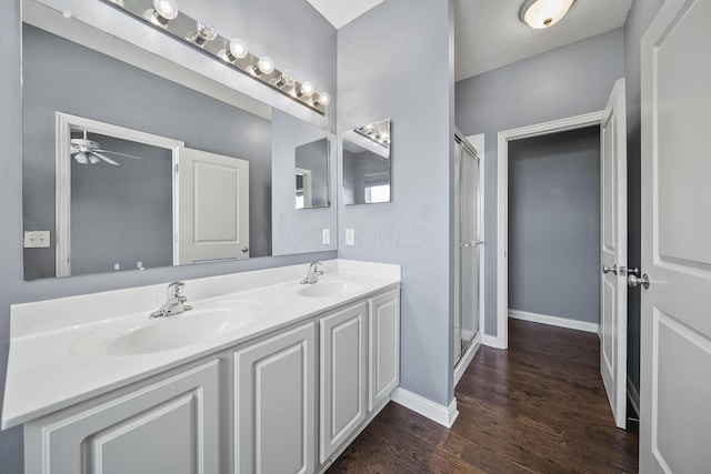 6067 Hayden Farms Rd, Dublin, OH 43016 - full bathroom featuring double vanity, a stall shower, wood finished floors, and ceiling fan