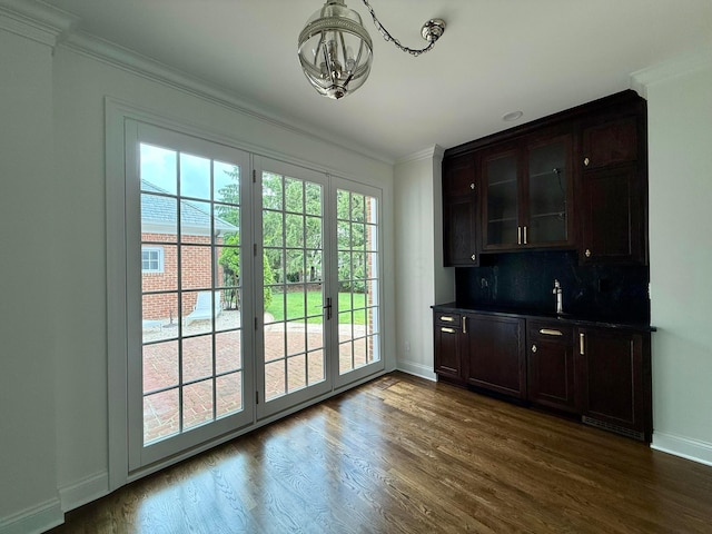 4945 Yantis Dr, New Albany, OH 43054 - bar featuring crown molding, a chandelier, dark wood finished floors, decorative backsplash, and french doors