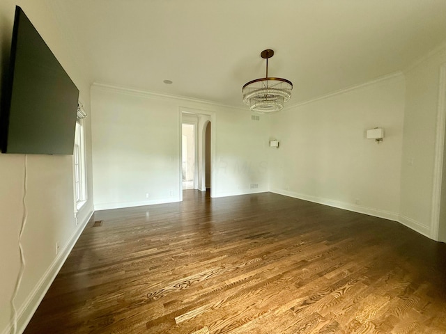 4945 Yantis Dr, New Albany, OH 43054 - empty room featuring ornamental molding, dark wood-type flooring, arched walkways, and a chandelier