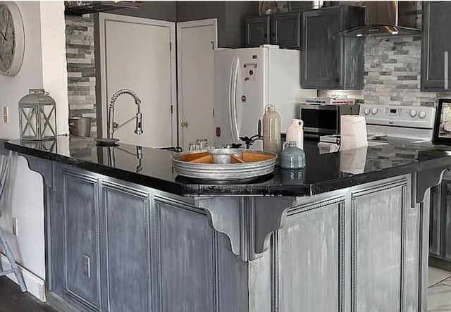 25327 Morris Salem Rd, Circleville, OH 43113 - kitchen featuring wall chimney exhaust hood, freestanding refrigerator, tasteful backsplash, stainless steel microwave, and a kitchen breakfast bar