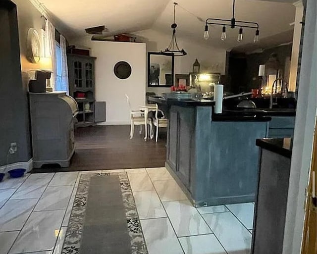 25327 Morris Salem Rd, Circleville, OH 43113 - kitchen with dark countertops, light marble finish floors, vaulted ceiling, and hanging light fixtures