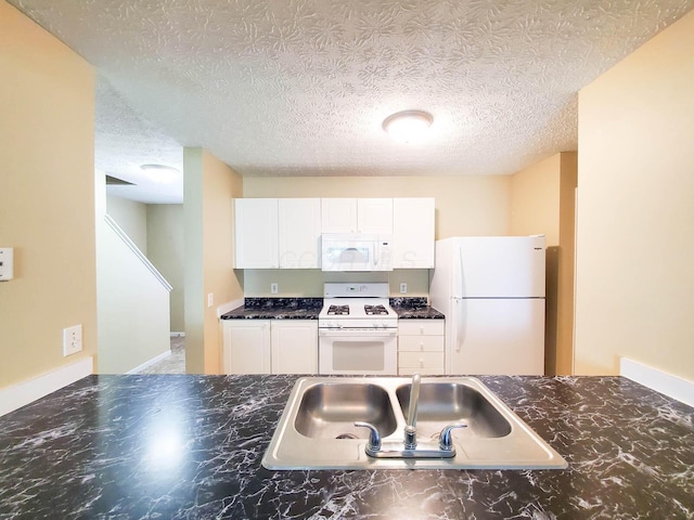 6140 Georges Park Dr Unit 8C, Canal Winchester, OH 43110 - kitchen featuring white appliances, dark countertops, white cabinetry, and a textured ceiling