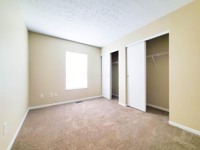 6145 Georges Park Dr Unit 9F, Canal Winchester, OH 43110 - unfurnished bedroom with multiple closets, carpet, and a textured ceiling